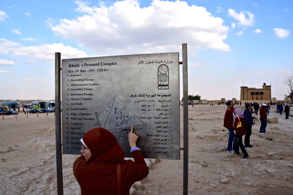 A local indicates the next site to visit on a map of the Great Pyramid of Egypt. 